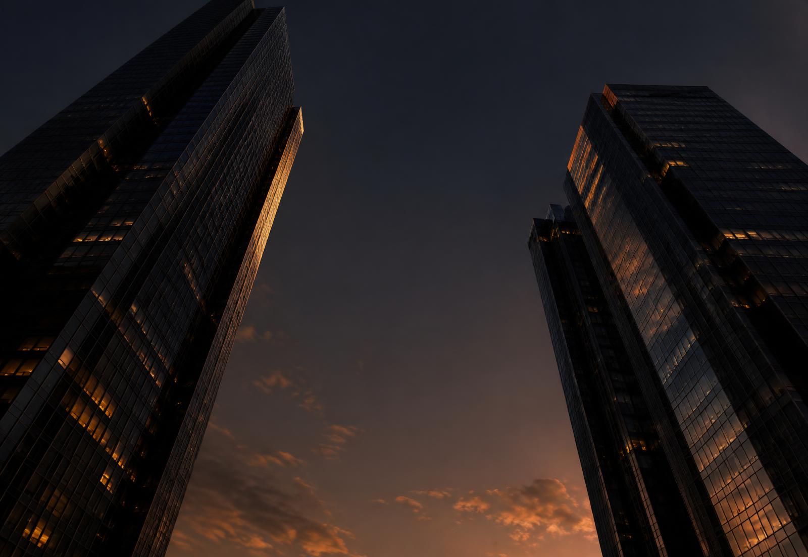 Twin high-rise towers rising into a dusk sky